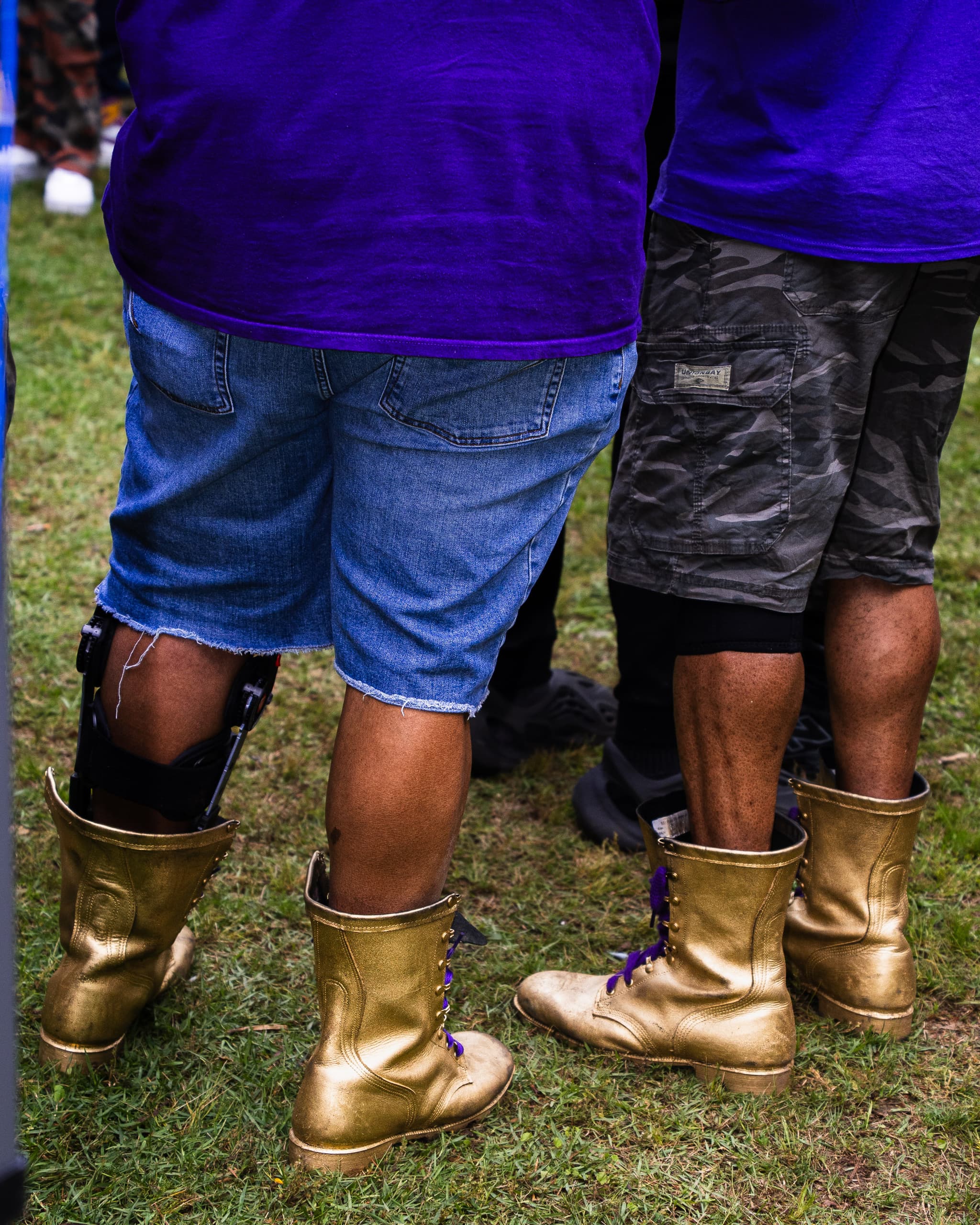 Gold boots and denim shorts on the grass at an outdoor gathering