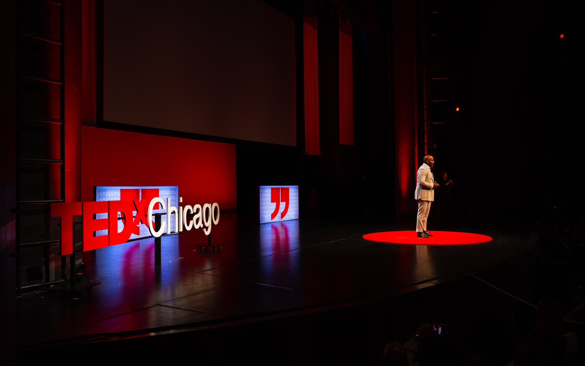 Speaker on the red circle of a TEDxChicago stage