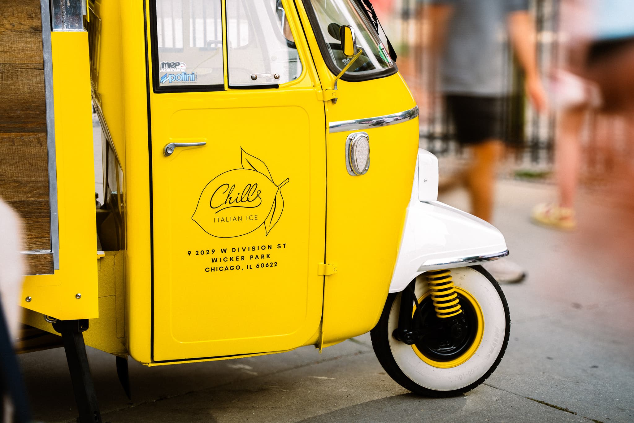 Bright yellow three-wheeled cart parked on a sidewalk