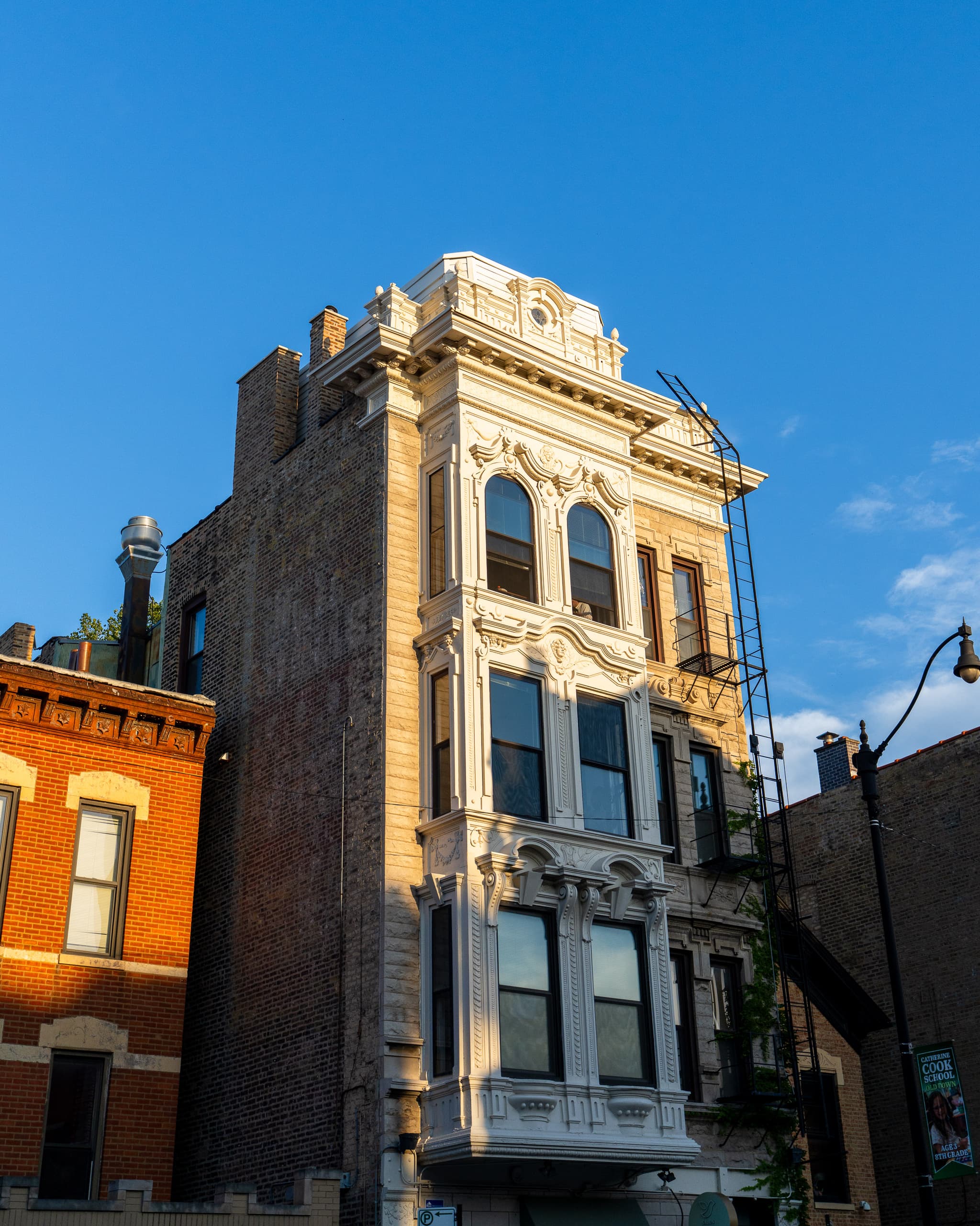 Ornate stone facade of an old corner building against a blue sky