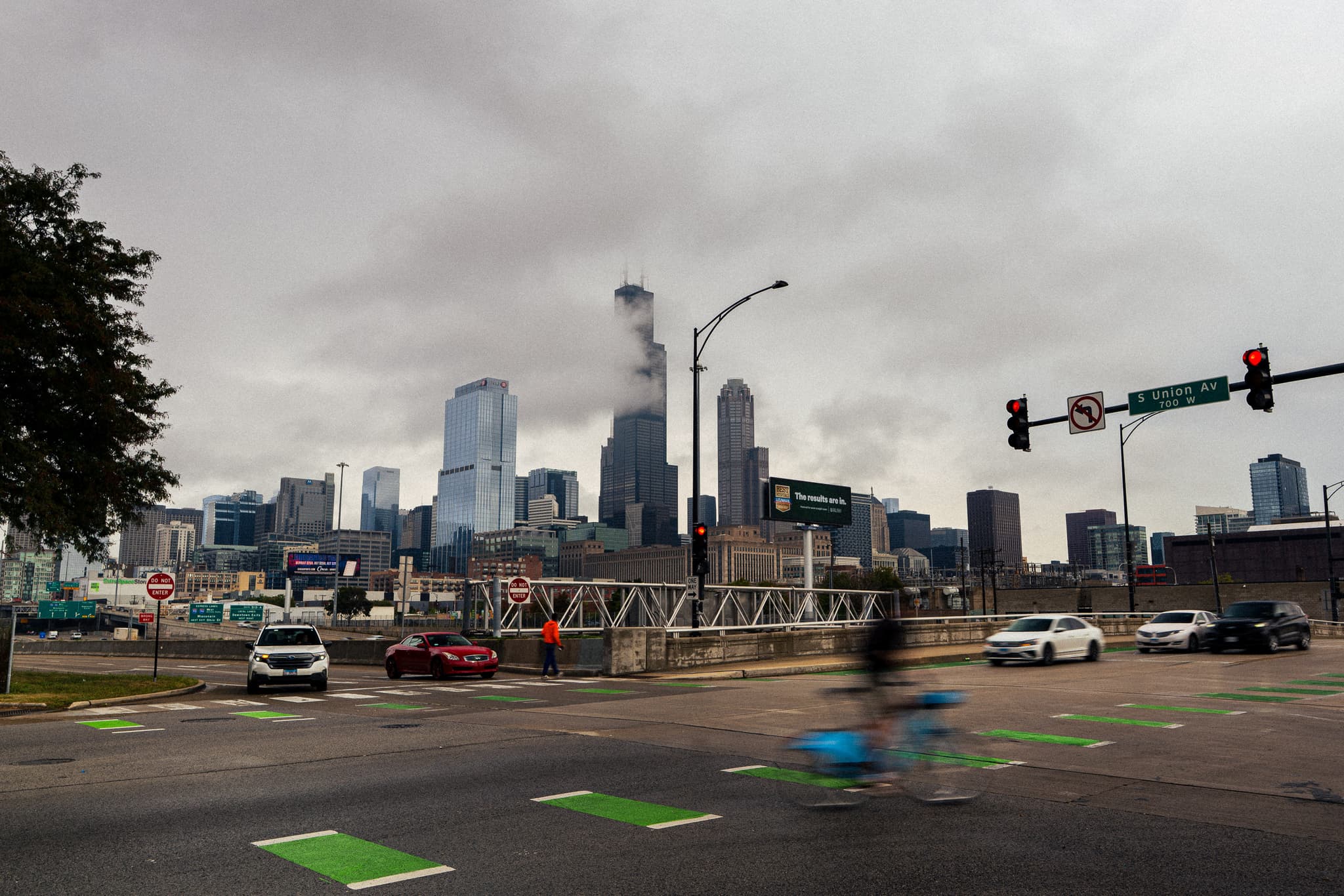Cyclist blurring through an intersection with the Chicago skyline ahead