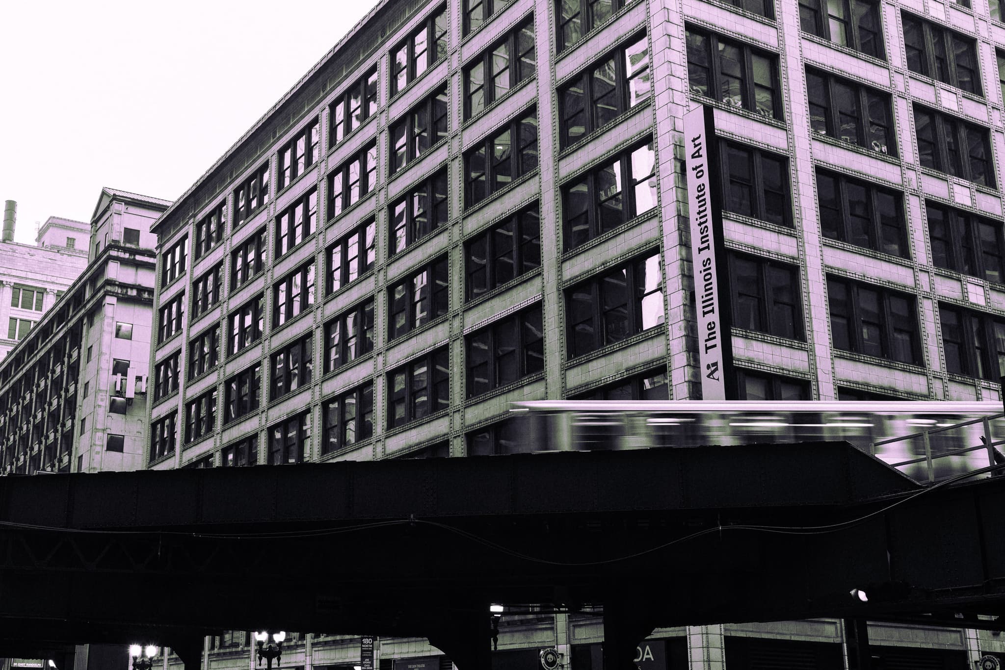 Elevated train passing in front of a gridded office building