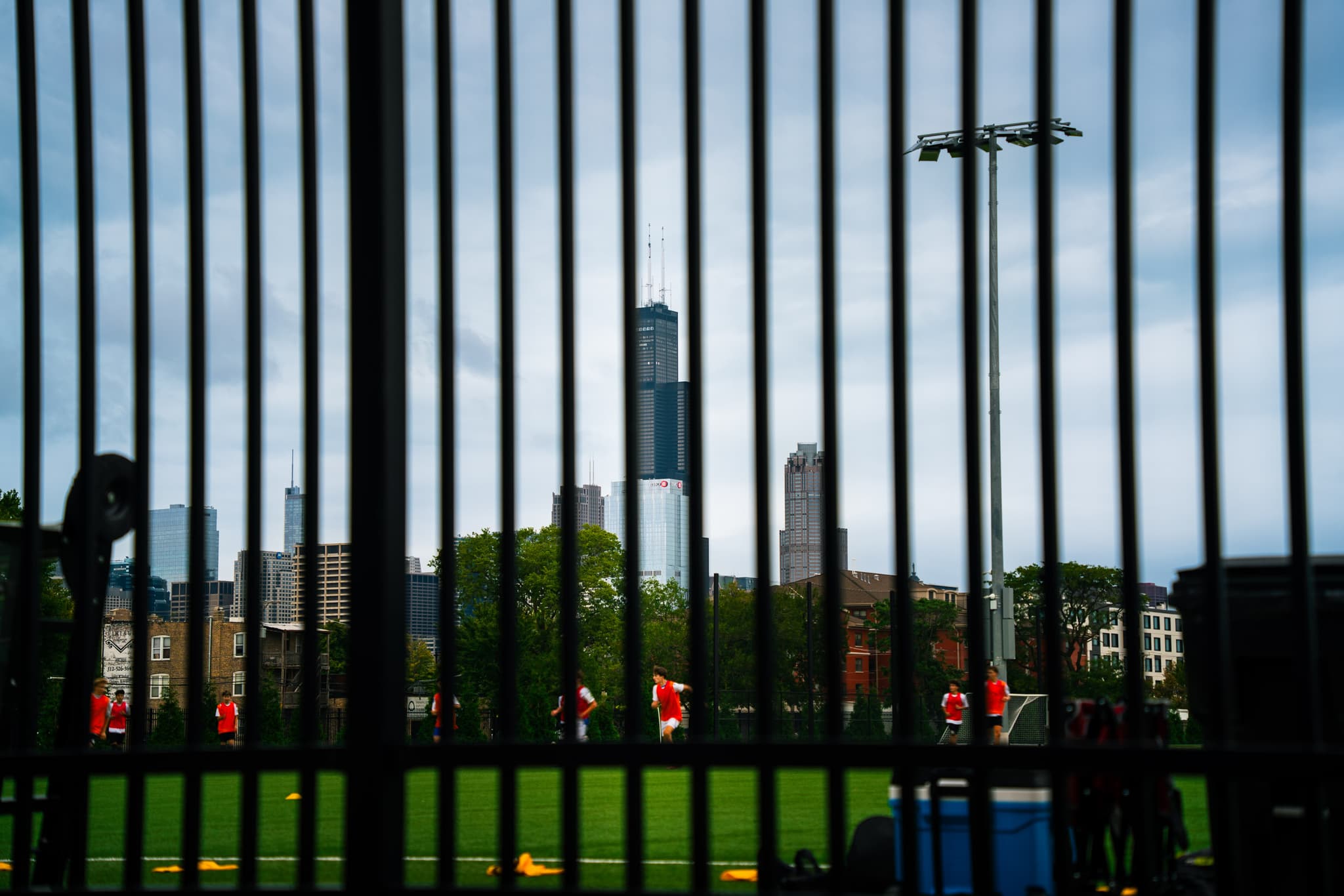 City skyline seen through black iron fence bars