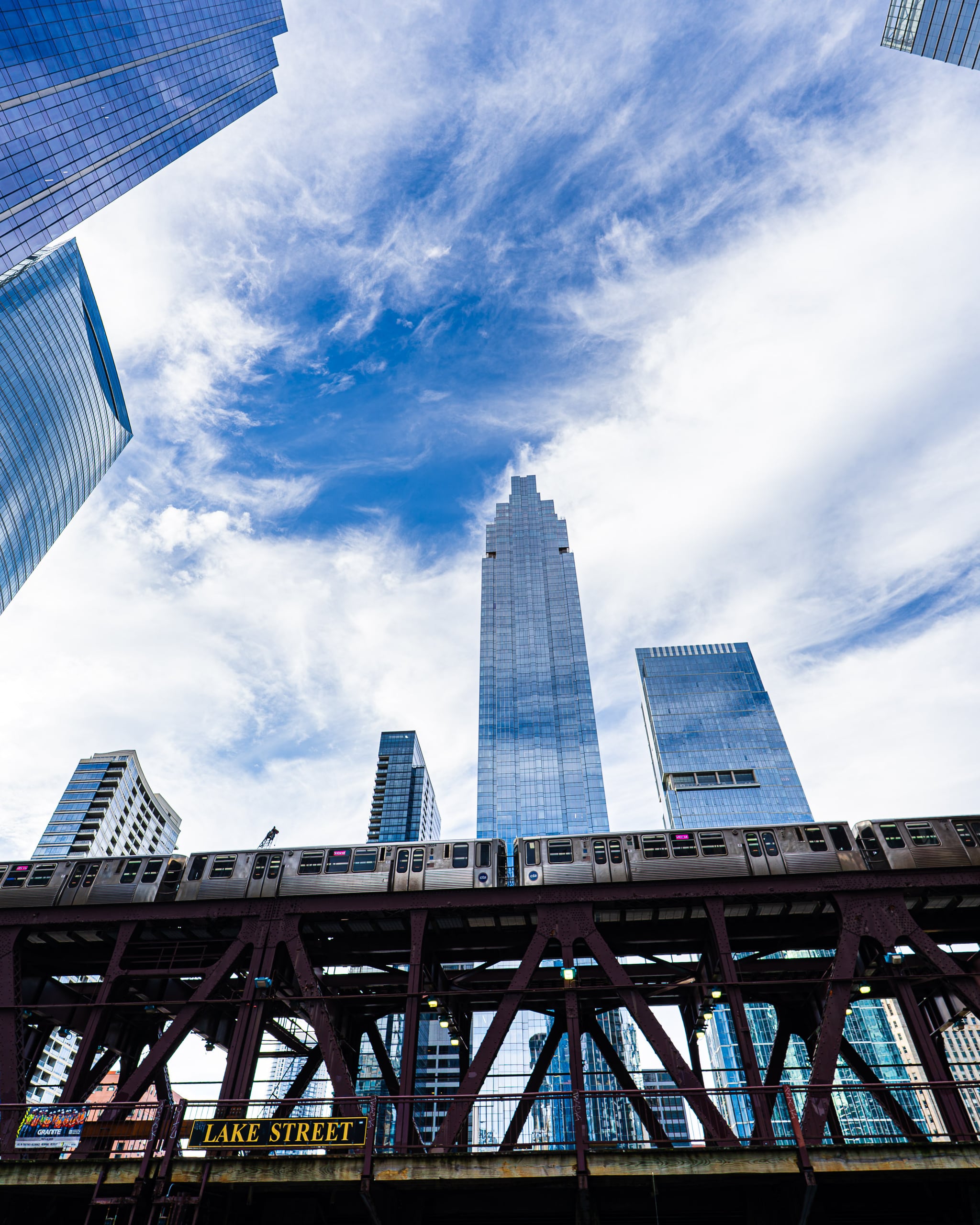 Glass towers and clouds above the elevated train tracks at Lake Street